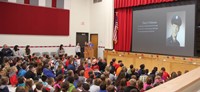 wide shot of student speaking at veterans day assembly