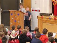 student speaking at podium at veterans day assembly