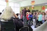 resident watching students sing