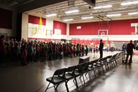 wide shot of students singing in gymnasium
