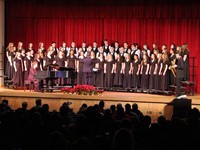 wide shot of chorus singing with mister hammill playing saxophone