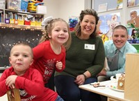 two adults and two students smiling