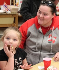 student eating cookie and adult