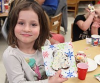 student holding gingerbread cookie