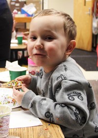 student smiling holding cookie