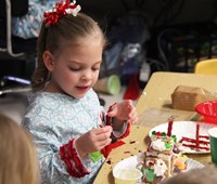 student decorating gingerbread house