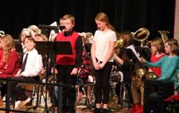 student speaking at podium at winter concert