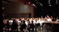 wide shot of band students performing from back of stage