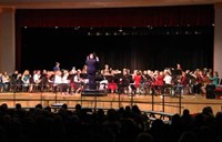 wide shot of band students performing from front of stage