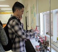 student touching hanging ornaments