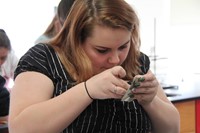 student putting tape on piece of metal