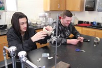 two students working on copper plating ornaments