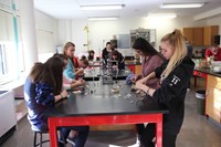 wide shot of students working on copper plating ornaments