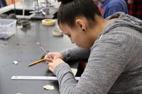 student cutting tape to put on metal