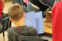 student holding blue paper