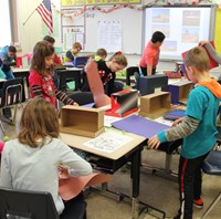 wide shot of students working on habitats in classroom