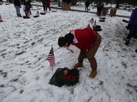 student putting wreath on grave