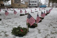 medium shot of line of graves with wreaths and American flags