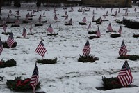 wide shot of people standing and taking wreaths out of boxes