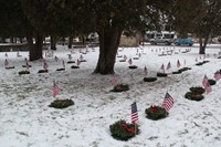 wide shot of wreaths and flags near graves