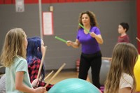 students and teacher participating in drums alive