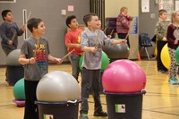 students holding up drum sticks for drums alive