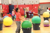 students holding drum sticks in the air