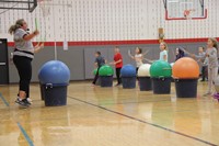 instructor and students bounce holding drum sticks