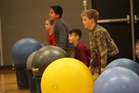 students standing by large exercise balls