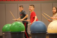 students smiling holding drum sticks