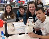 more students holding doll they mummified