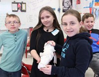 students holding doll they mummified