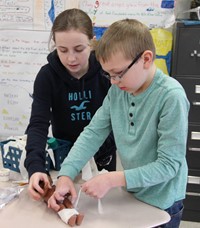 students mummifying doll