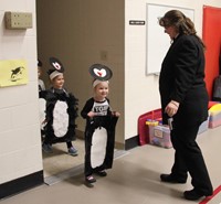 more students entering gym dressed as penguins