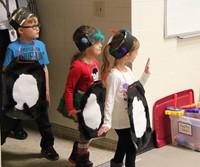 three more students dressed as penguins