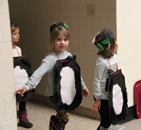 three more students dressed as penguins