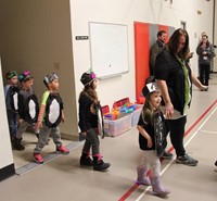 students dressed as penguins entering gym