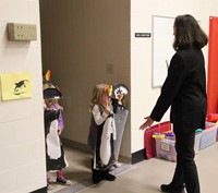 students dressed in penguin costumes entering gym