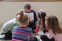 elementary students looking up close to book illustrations