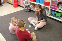 high school student talking to elementary students