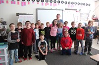 second grade class smiling with teacher