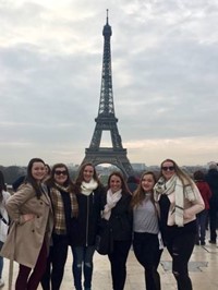 students and teacher in front of eiffel tower