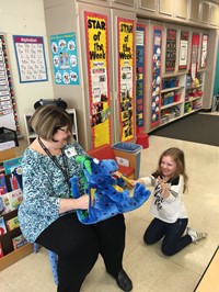 another student brushing toy dragons teeth