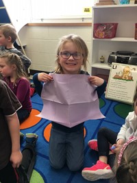 student holding up bib