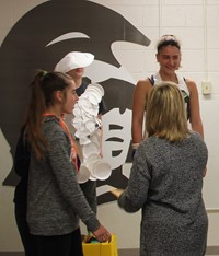 teacher and student talking to student dressed in recycled items