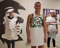 three students taking part in recycled fashion show