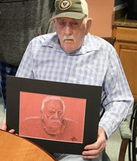 man sitting holding drawing