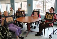 four residents holding drawings of them