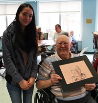 student standing next to man holding drawing