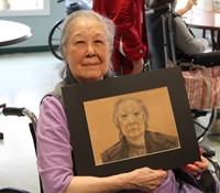 woman smiling holding picture of herself